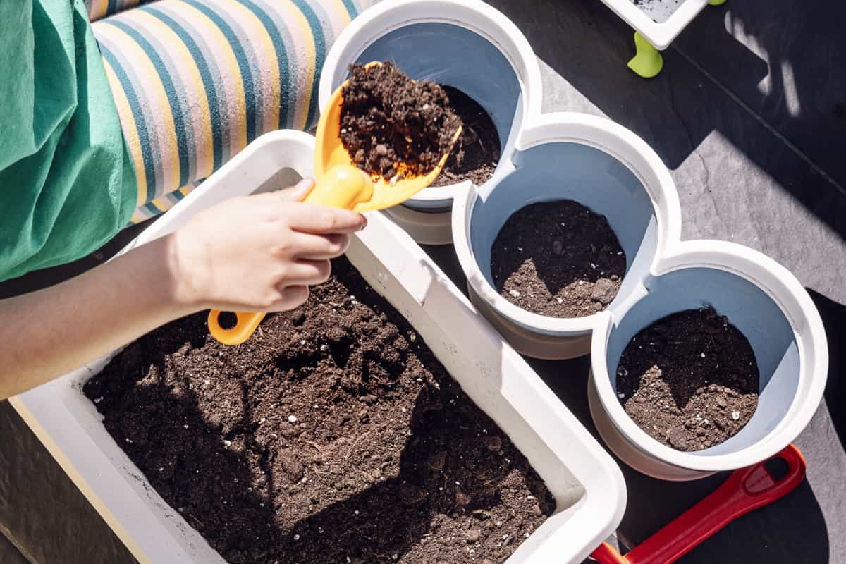 Putting soil in pots with a shovel